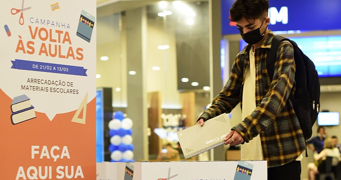 Cliente no shopping da Aliansce Sonae realizando doação de material escolar