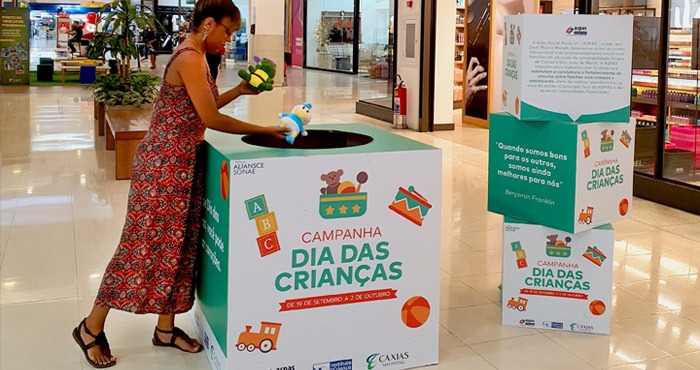 Mulher doando brinquedo no Shopping da Aliansce Sonae