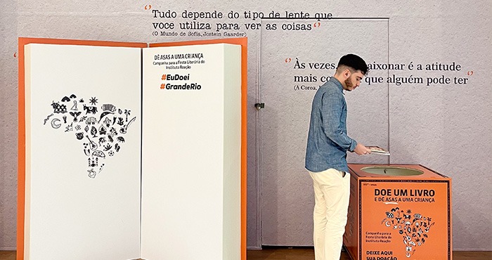homem doando livro para Festa Literária do Instituto Reação